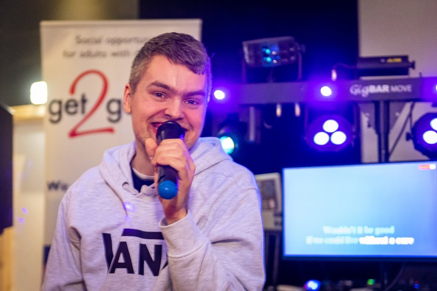 get2gether member smiling and holding a microphone at get2gether's Karaoke Disco